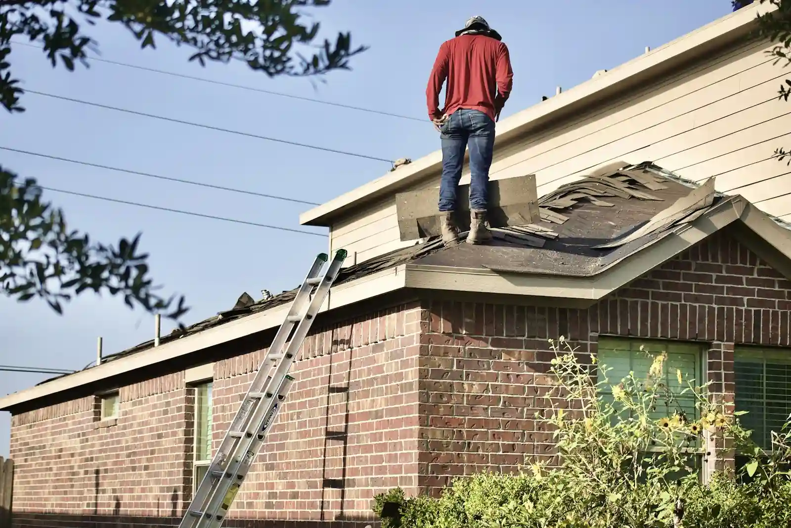 Worker on roof with ladder